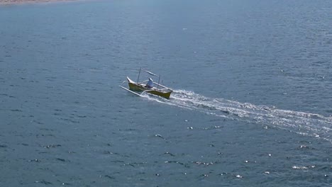 drone following a fishing boat in mabua's clear waters in surigao philippines