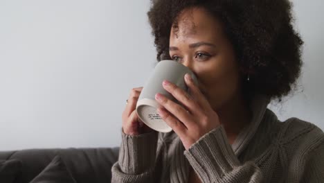 Woman-having-a-coffee-in-living-room