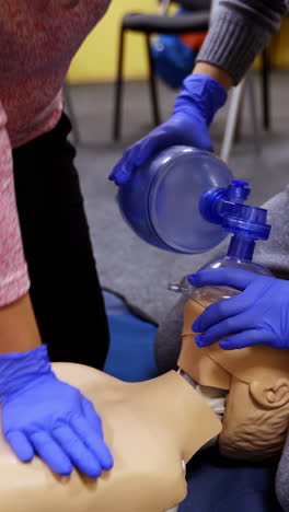 medical practice to save life. students in medical gloves learning to do a cpr on a dummy in training center. adult cpr training and first aid. vertical video