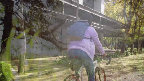 Animation-of-trees-over-african-american-woman-cycling