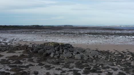 Rocky-beach-mound-of-boulders-sitting-on-shore-of-lough