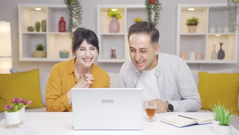 pareja aplaudiendo lo que ven en la computadora portátil. exitoso y emocionante.