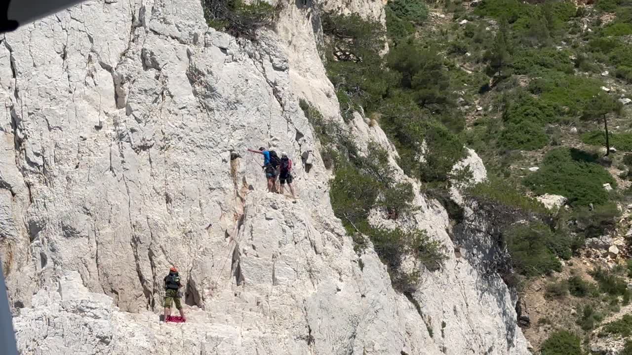Group of mountain climber on steep cliff of Cote d azure in France. Sunny day in summer. Tracking slow motion shot.