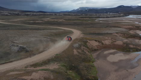 Birds-eye-view-off-road-jeep-driving-in-wild-landscape,-Iceland.-Aerial-view-4x4-vehicle-speeding-traveling-across-mossy-and-desert-icelandic-countryside.-Adventure-and-exploring.-Travel-destination