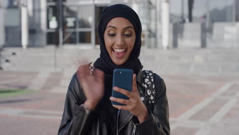 Retrato-Hermosa-Joven-Musulmana-Usando-Video-Chat-De-Teléfono-Inteligente-Disfrutando-Hablando-Por-Teléfono-Móvil-Sonriendo-Emocionada-Mujer-étnica-Usando-Hijab-En-Cámara-Lenta-De-La-Ciudad