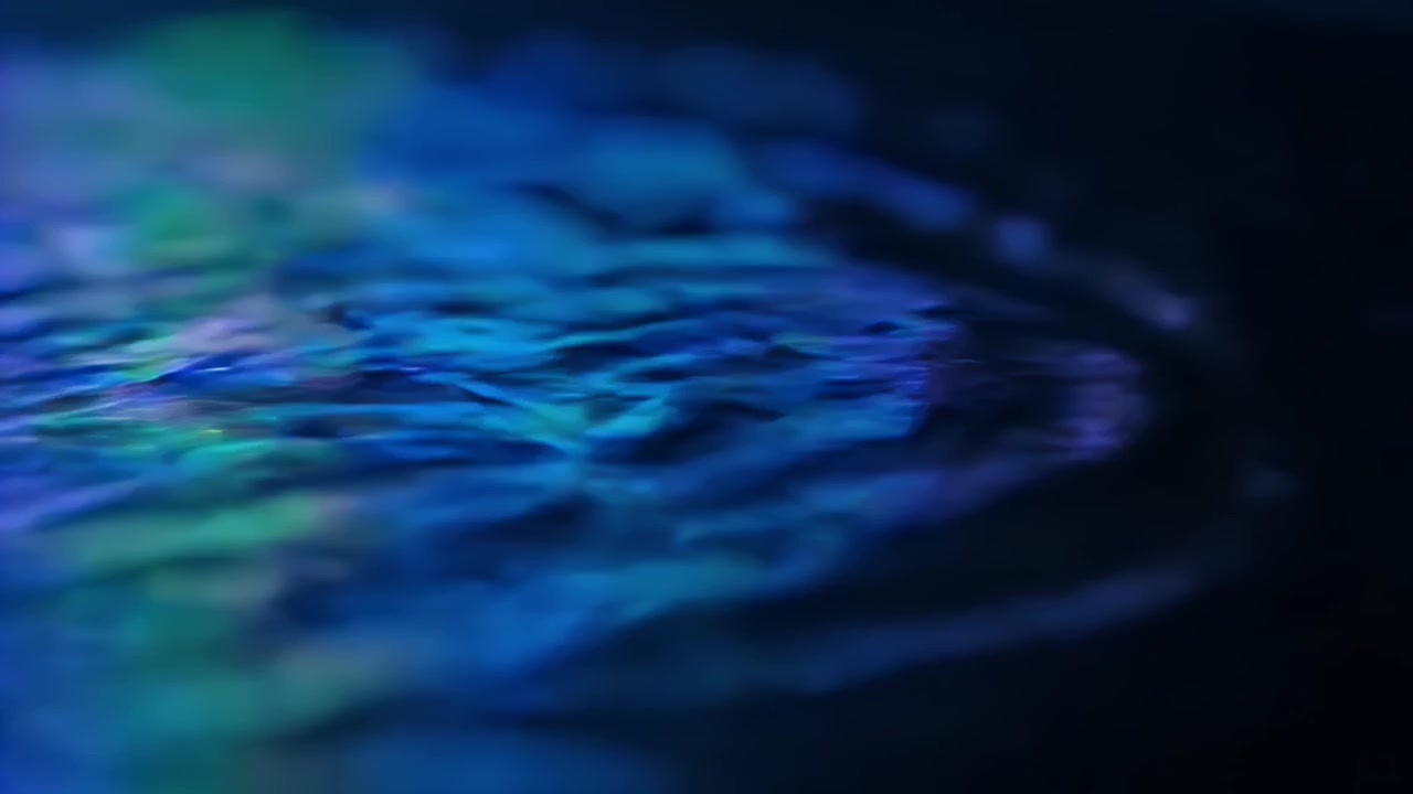 Increspature astratte su superficie d'acqua scura con riflessi colorati