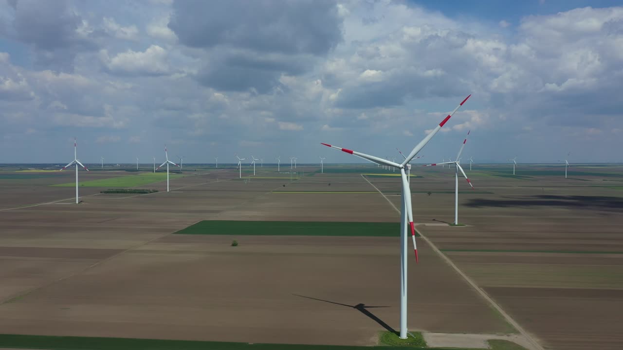 воздушный вид нескольких ветряных мельниц, ветряных генераторов, турбин, производящих возобновляемую чистую энергию путем преобразования кинетической энергии