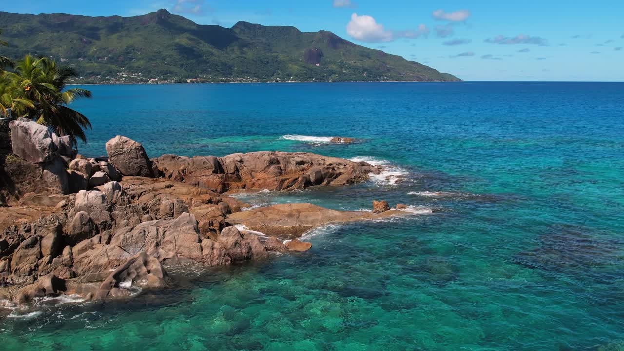 rone shot of granite rock boulders and calm sea water on the sunset beach, Mahe Seychelles, slow motion