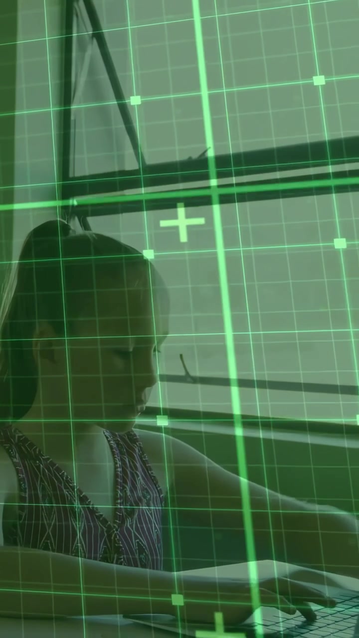 Vídeo vertical: Menina digitando em laptop perto da janela, ativando grade HUD verde para aprendizado