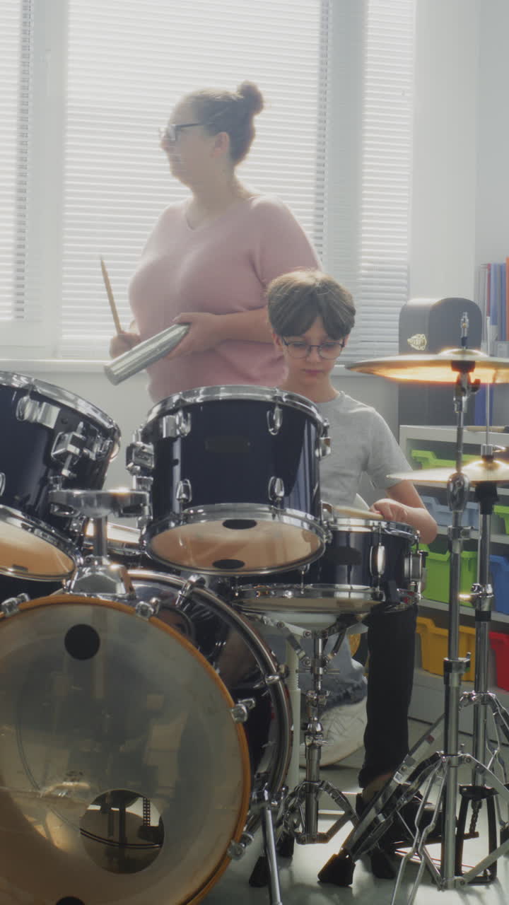 Primary School Boy Practicing Sense of Rhythm Playing Drums in Music Class