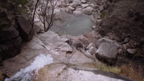 Gimbal-Reveal-Slow-Motion-Shot-of-Pond-at-the-Base-of-Waterfall