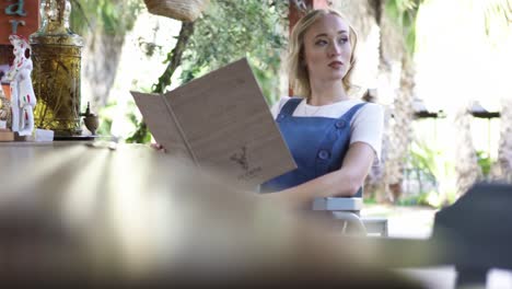 woman reading a menu in an outdoor cafe