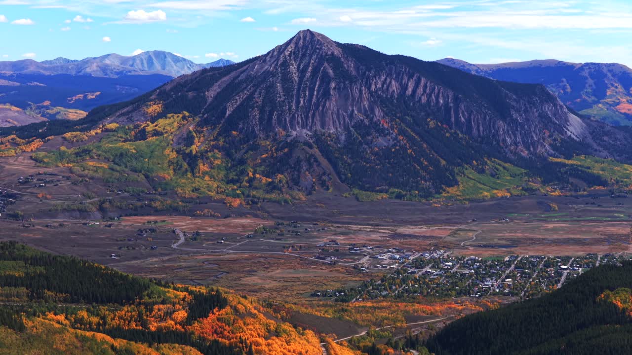 Mount Crested Butte Colorado drone aerial fall Elk Range Rocky Mountains Crested Butte ski resort town autumn Quaking colorful Aspen Trees blue skies clouds Coal Creek Kebler Pass backwards pan up