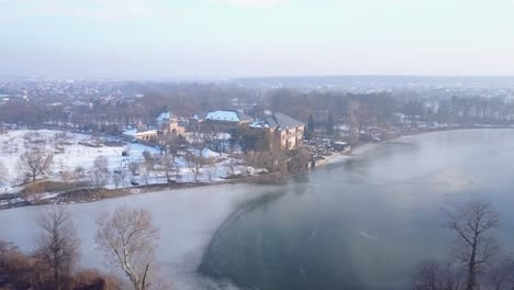 Volando-Sobre-Un-Lago-Congelado-Hacia-El-Palacio-Brancoveanu-De-Mogosoaia,-Bucarest,-Rumania