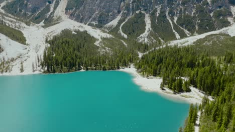 aerial drone shot of the dolomites alps, the river and the mountains, lago di braies, italy, dolomites