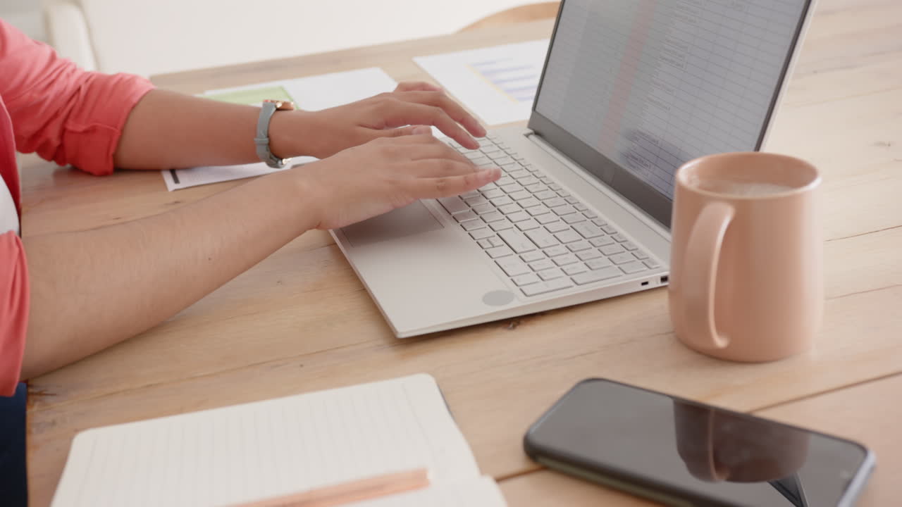 Typing on laptop, asian woman working at desk with smartphone and coffee mug, at home, copy space