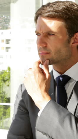 thoughtful businessman looking out window