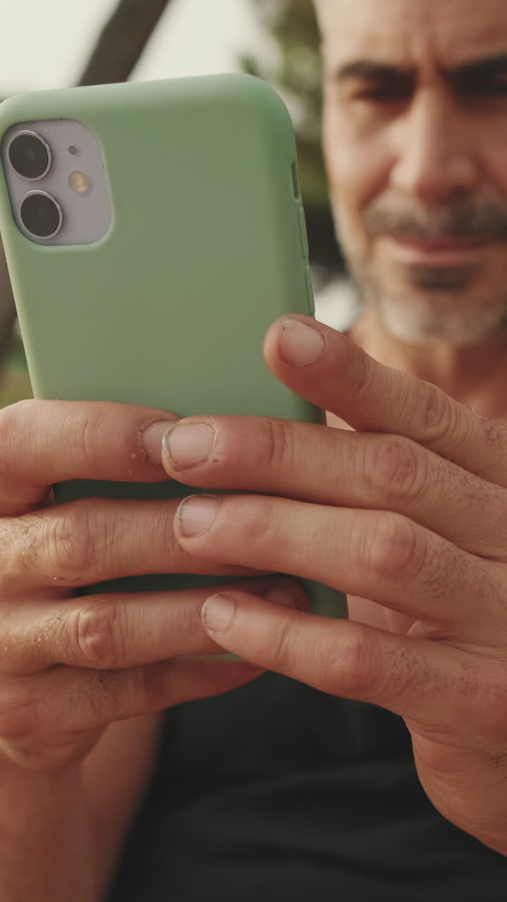 Uomo che tiene in mano un telefono verde