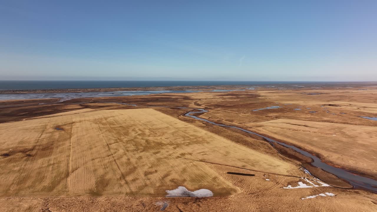 Breathtaking drone flight over the vast golden plains of Iceland, following the winding Þjórsá River.
