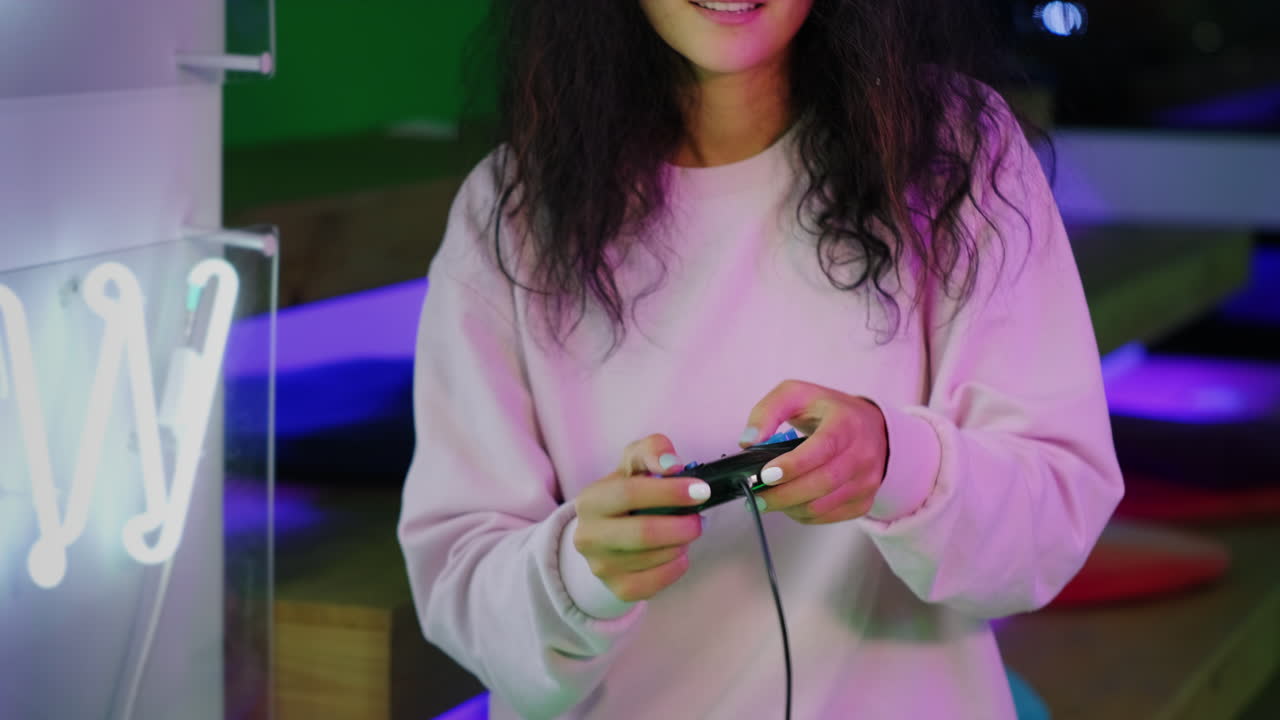 donna che gioca a videogiochi in una sala giochi illuminata al neon