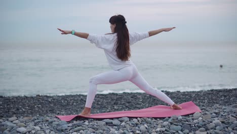 woman practicing yoga on a beach