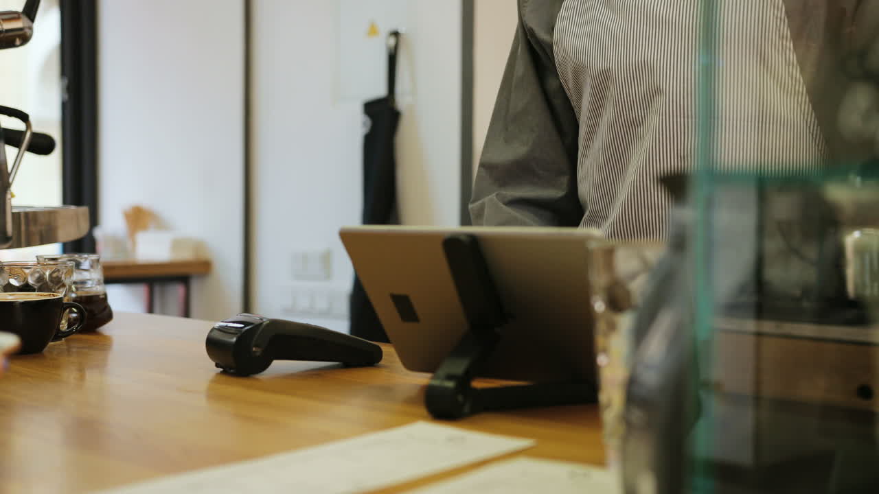 고객의 신용 카드로 커피 값을 지불하는 바리스타 손의 클로즈업 보기