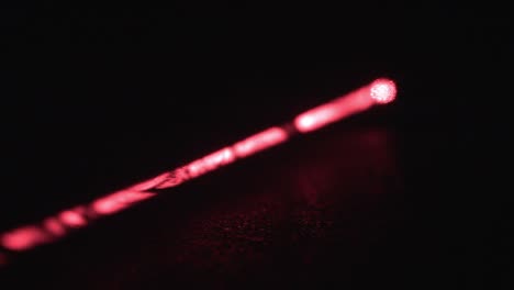 haz de láser rojo largo con partículas de polvo sobre fondo negro