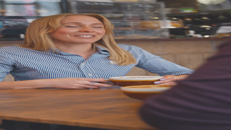 vertikales video eines reifen paares, das an einem tisch im café sitzt und sich über ein date unterhält