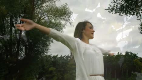 mujer de vestido blanco girando en un bosque