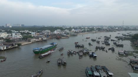 ship freighter passes crowd of river boats at cai rang floating market