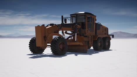 road grading machine on the salt desert road