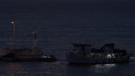 in nea kallikratia greece in night sea near the lighthouse sails ship and stops at the pier