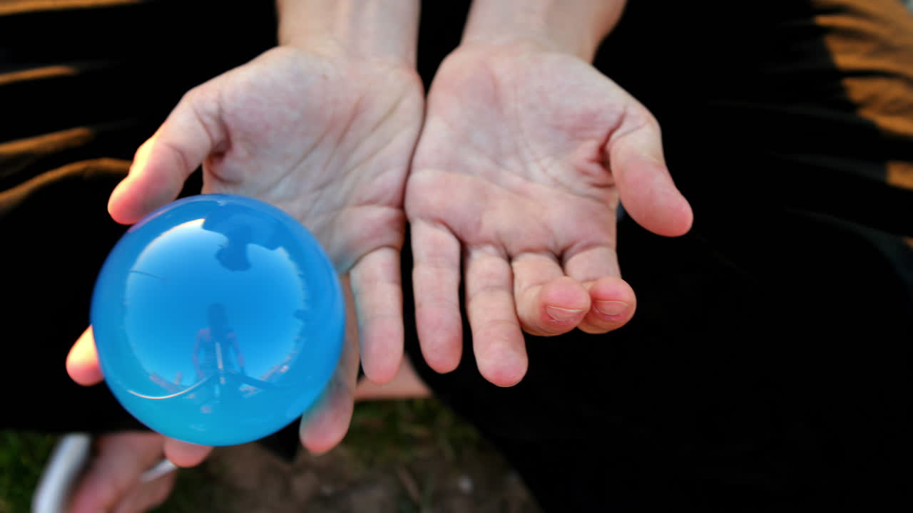 Female with glass juggling sphere