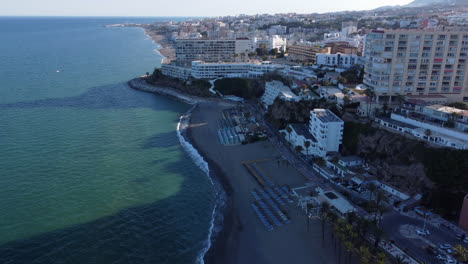 aerial reveal tilt up of torremolinos beach and hotel coastline