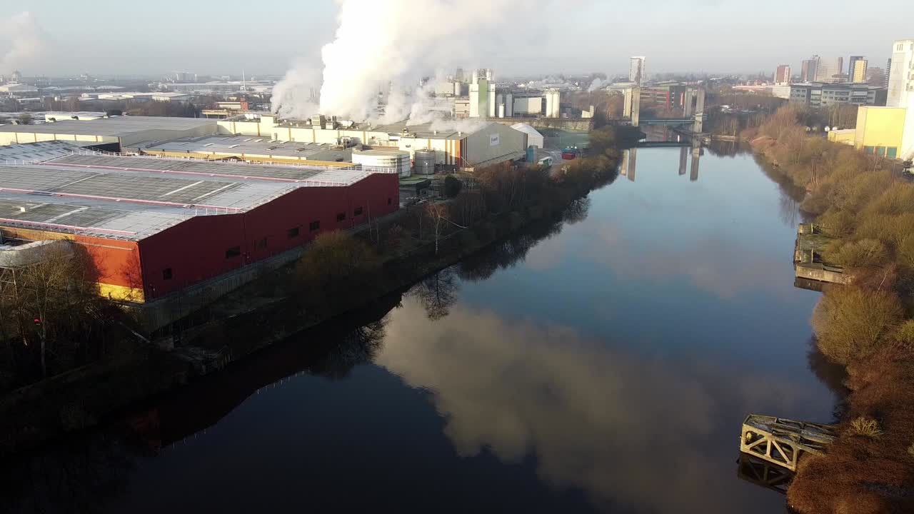 Luftfoto af generelle fabrikker og industri over Manchester Ship Canal med forurening.