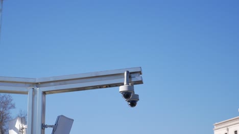 security cameras mounted on a pole against a blue sky