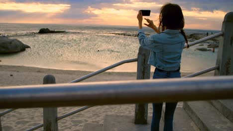 woman clicking photos with mobile phone at beach 4k