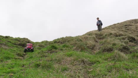 Young-boy-outdoors-on-the-moors-playing-with-his-RC-Car,-Truck,-4-x-4