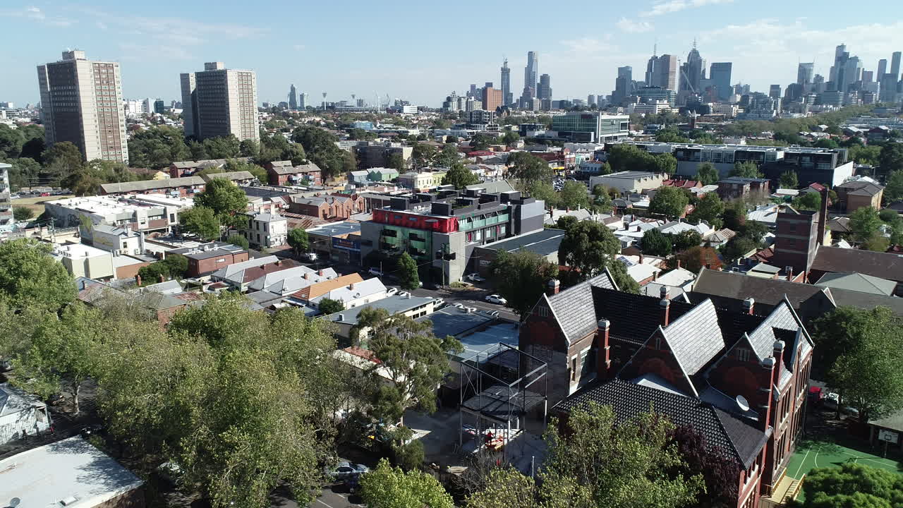 전경에 구식 학교가 있는 멜버른 도심 스카이라인과 커미션 타워의 원활한 상승 및 공개