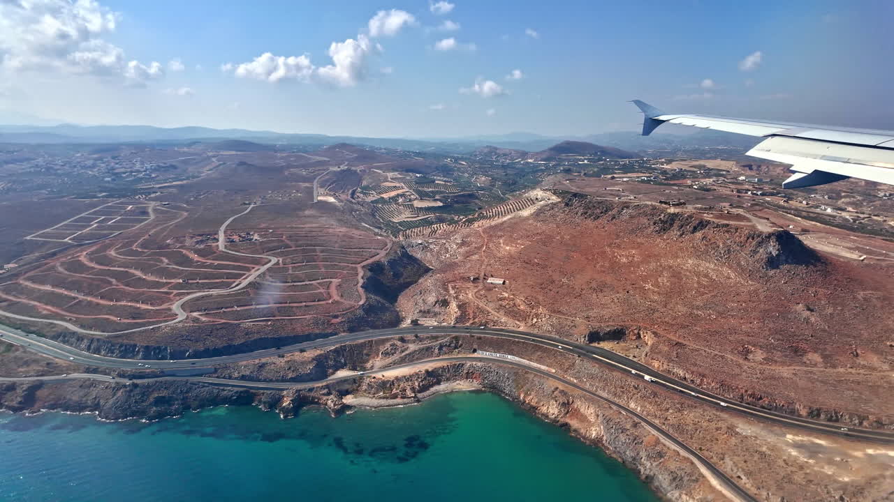 비행기 창문에서 볼 수 있는 크레타의 해안선의 공중 풍경, 푸른색 물과 거친 절벽