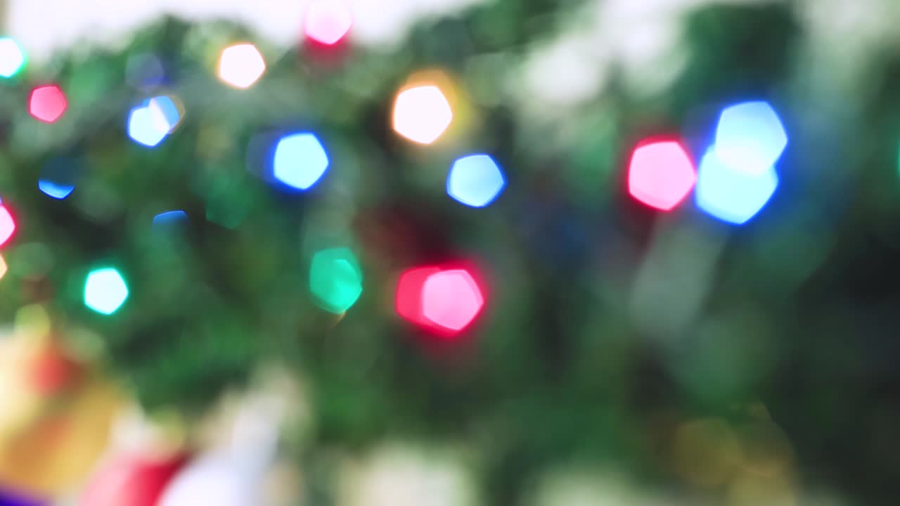 Luzes coloridas de Natal brilham intensamente fora de foco.