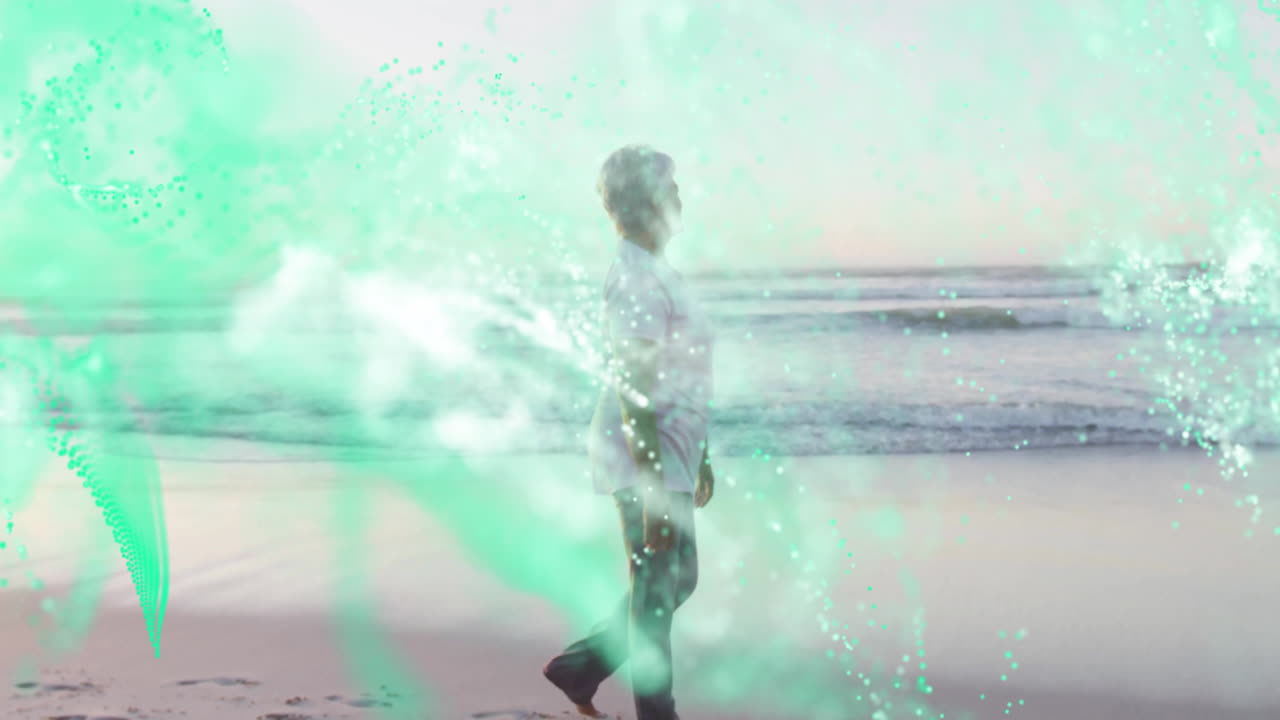 Senior woman walking on sandy beach shoreline, showing teal technology data particle overlays