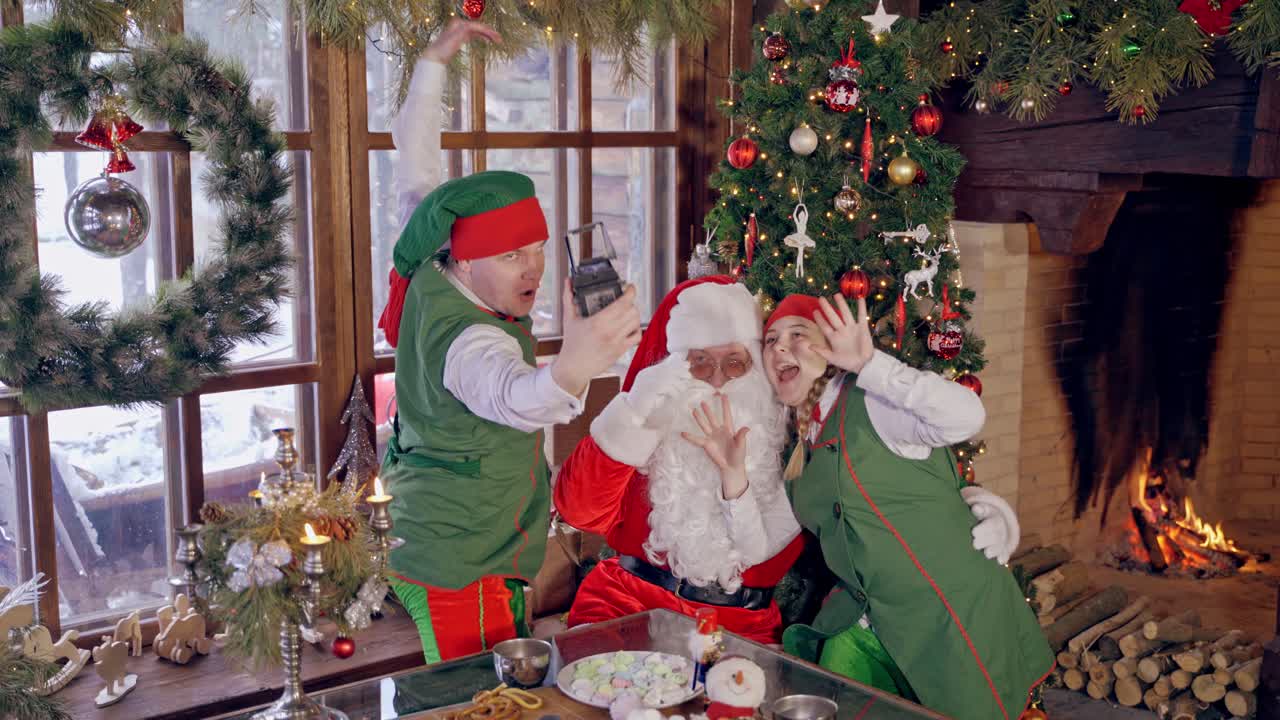 Santa Claus makes selfies. Santa Claus with elves makes selfy with retro camera