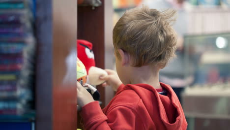 cute little boy shopping for toys