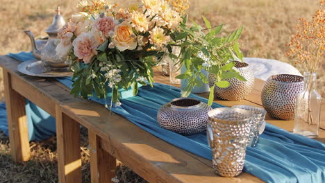 Vibrant-rustic-table-decor-ornament-with-turquoise-tablecloth-and-floral-arrangements---Close-up-pull-out-shot