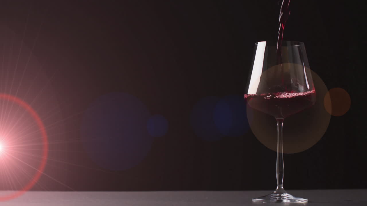 Kompositbillede af rødvin, der hældes i glas over mørkerød baggrund