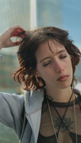 Vertical-Video-Outdoor-Fashion-Portrait-Of-Young-Alternative-Style-Woman-With-Tattoos-And-Piercing-Standing-Outside-Modern-Buildings-At-Canary-Wharf-London-Shot-In-Real-Time-3