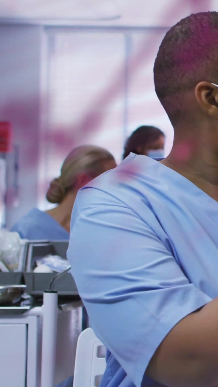 Vertical video: Medical worker pointing at clear board as pink notes appear, planning medical steps
