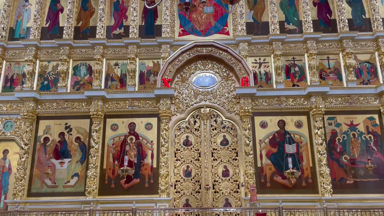 Blick nach unten im Inneren der Mariä-Himmelfahrt-Kathedrale, Astrachaner Kreml. Ein kunstvoller Kronleuchter und eine goldene Ikonostase mit orthodoxen Ikonen heben die russische religiöse Architektur und das Kulturerbe hervor.