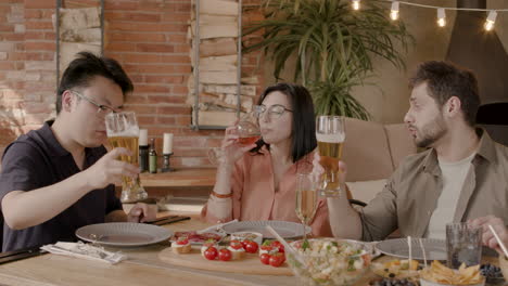 A-Group-Of-Three-Friends-Toast-With-Their-Glasses-At-A-Dinner-Party-1